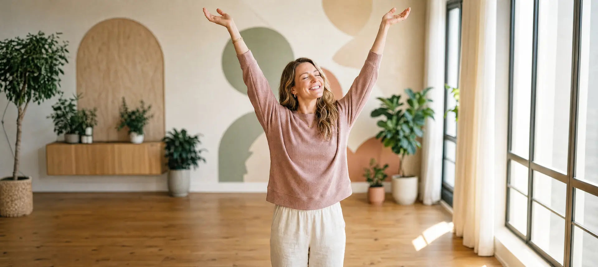 A smiling woman with curly hair holding a glass of water and taking a supplement capsule. Morning wellness routine and daily vitality.