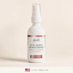 A white spray bottle of Glenari Anti-Aging Moisturizer with a clear cap, set against a warm beige background. The bottle features a white label with dusty rose accents and condensation droplets.