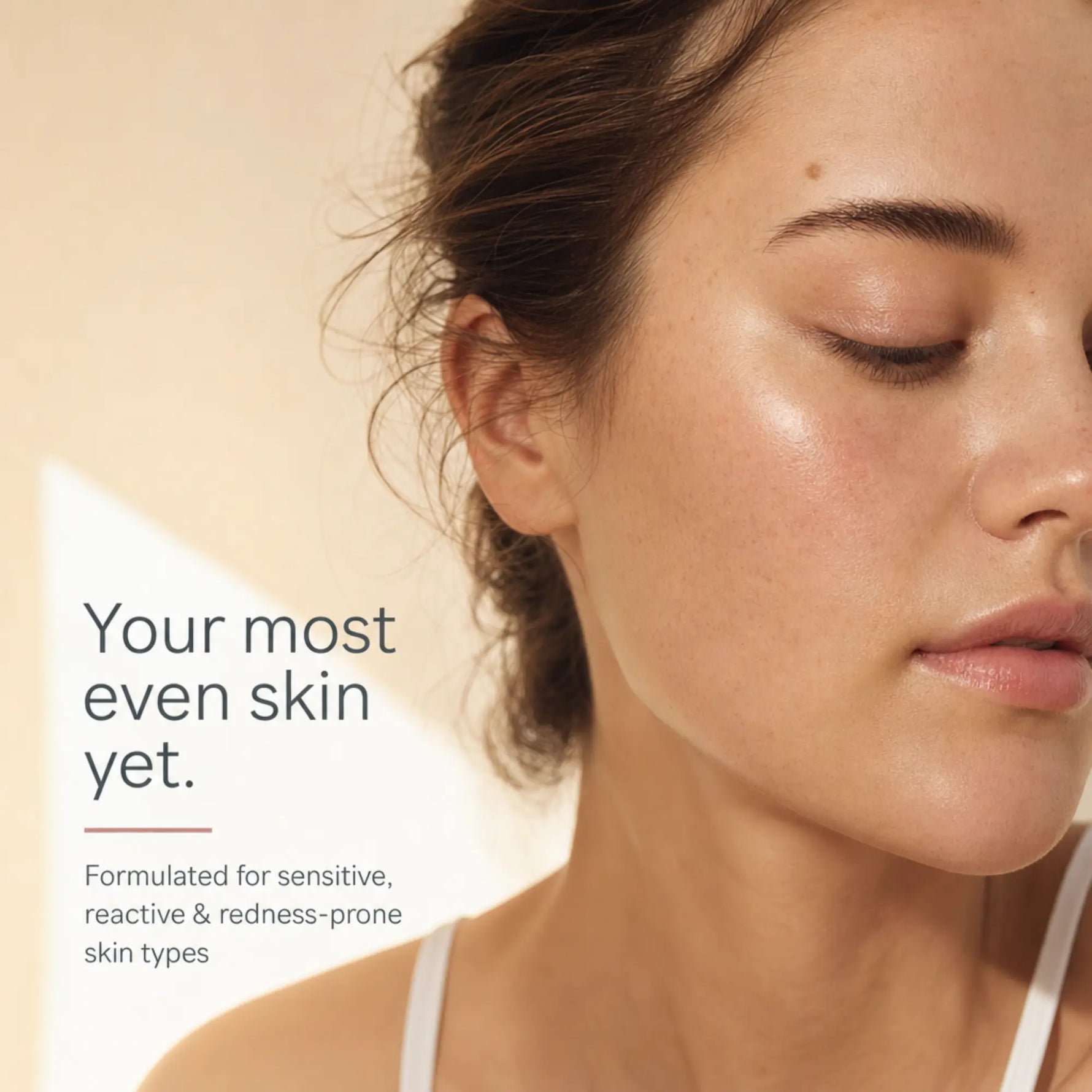 Close-up of a woman with closed eyes and smooth, even skin, with text on the left reading 'Your most even skin yet.' and smaller copy about formulated for sensitive, reactive & redness-prone skin types.