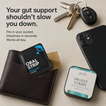 A flat-lay product shot showing oral support strips in a brown leather wallet and a small square tin, alongside keys, a smartphone, and a kraft envelope on a beige background. Text reads: 'Your gut support shouldn't slow you down.