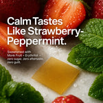 A square amber-yellow candy or gummy piece rests on white sugar crystals, surrounded by fresh strawberries and mint leaves. Large white text reads, 'Calm Tastes Like Strawberry-Peppermint.