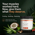 A jar of Glenari Recovery Cream coconut oil & shea butter shown on a dark green background with promotional text, aloe vera leaves, a coconut, nuts, and red berries around it.